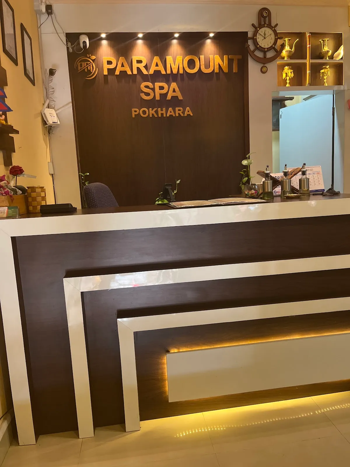 The Paramount Spa Pokhara reception desk with gold lettering on a wood wall